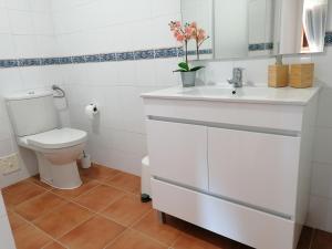 Baño blanco con aseo y lavamanos en Apartamento Riomar, en Vila Nova de Milfontes