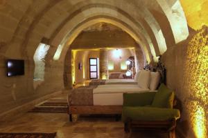 a bedroom with two beds and a couch in a room at Kayra Cave Suites in Goreme