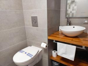 a bathroom with a white toilet and a sink at Duplex a 25 metros de la playa in Somo +23 photos