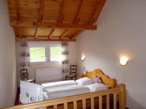 una camera da letto con un grande letto con lenzuola bianche di Hotel Restaurant La Petite Auberge Alsace a Le Hohwald
