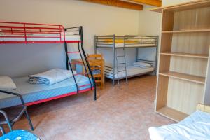 Zimmer mit 2 Etagenbetten und einem Tisch in der Unterkunft Quartier Penne-Projekthaus 