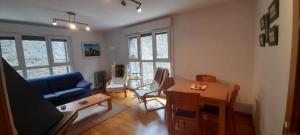 a living room with a blue couch and a table at Buenavista in Canfranc