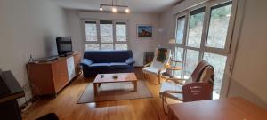 a living room with a blue couch and a table at Buenavista in Canfranc