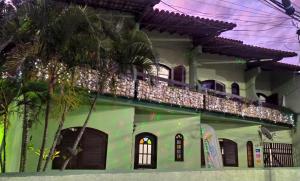 un edificio verde con balcón en la parte superior. en Arraial do Cabo - suite, en Arraial do Cabo