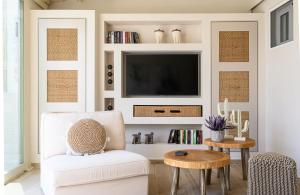sala de estar con silla blanca y TV en Fiorela's casa- A stylish loft apartment in the heart of Preveza en Preveza