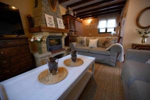 a living room with a couch and a fireplace at Casa rural la castañona in Buiza