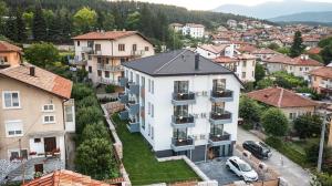 a large white apartment building in a city at "The House" Апартаменти и Термална зона in Velingrad