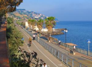 een straat naast de oceaan met mensen die fietsen bij Narciso Centralissimo in Sanremo