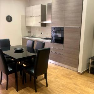 a kitchen with a table and chairs and a kitchen with a stove at Portuense Sweet Home in Rome