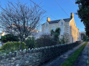 a white house with a stone wall at Bryn Noddfa in Morfa Nefyn