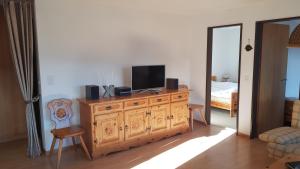 ein Wohnzimmer mit einem TV auf einer Holzkommode in der Unterkunft Ferienwohnung Silberdistel in Bellwald
