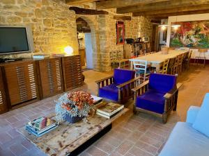 Una sala de estar con una mesa y sillas y un televisor. en La Corte del Gusto LuxuryApartments, en Arcevia