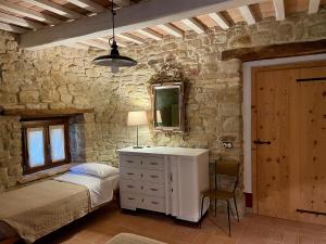 a bedroom with a bed and a dresser and a mirror at La Corte del Gusto LuxuryApartments in Arcevia