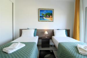 アルブフェイラにあるAlbufeira Prestige With Pool by Homingのベッド2台が備わる部屋、壁に絵が飾られた部屋 +41枚の写真