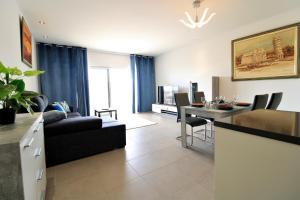 アルブフェイラにあるAlbufeira Prestige With Pool by Homingのソファとテーブルのあるリビングルーム
