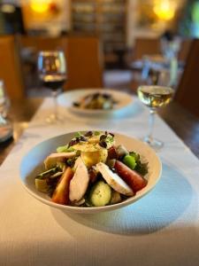 a plate of food on a table with wine glasses at Domaine du Moulin d'Asselborn in Asselborn