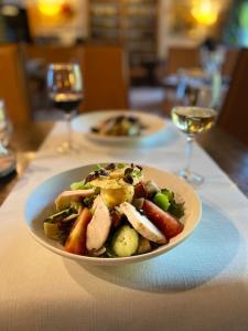 un plato de comida en una mesa con copas de vino en Domaine du Moulin d'Asselborn, en Asselborn