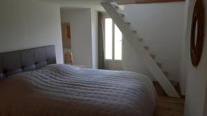 um quarto com uma cama grande e uma escada em Gîte Maison des Poules em Marvejols