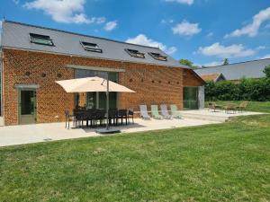 Gergny的住宿－Gîte un Air de Campagne，庭院配有桌子、遮阳伞和椅子