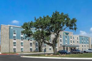 ein großes Gebäude mit einem Baum davor in der Unterkunft WoodSpring Suites Austin Georgetown in Georgetown