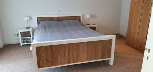 - un grand lit dans une chambre avec 2 tables de nuit dans l'établissement Vakantiehuis de wilgenhof, à Wetering