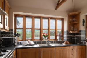 een keuken met een wastafel en een raam bij Beautiful Countryside cottage on the North Wales Coast in Abergele