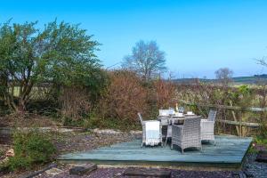 アベルゲレにあるBeautiful Countryside cottage on the North Wales Coastの木製デッキに座るテーブルと椅子