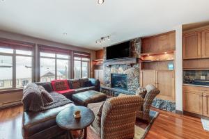 a living room with a couch and a fireplace at Southpoint #23 in Big White