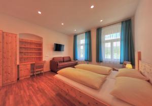 フェルデン・アム・ヴェルターゼーにあるSeeappartements Bundschuhのベッドルーム1室(ベッド2台、ソファ、椅子付)