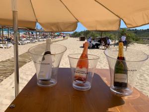 グラン・アラカントにあるCosta Hispaniaのビーチの木製テーブルの上に座ったシャンパン2本