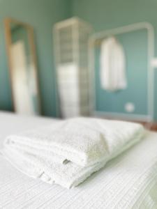 a white towel sitting on top of a bed at Blue Bay Apartment in Setúbal +31 photos