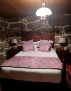 a bedroom with a large bed with pink pillows at Welcoming villa near Penafiel with pool in Abol de Cima