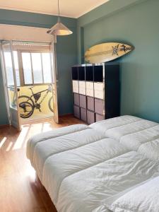a room with two beds and a surfboard on the wall at Blue Bay Apartment in Setúbal