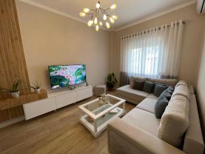 a living room with a couch and a flat screen tv at Joni & Joy Center Apartment in Berat