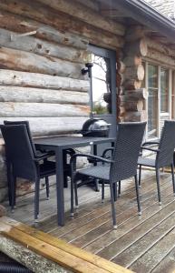 a black table and chairs on a wooden deck at Salmikangas G4 in Ruka