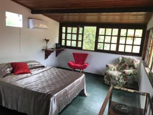 Schlafzimmer mit einem Bett, einem Stuhl und Fenstern in der Unterkunft CASA SURYA, Piscina Fantástica, Churrasqueira, Completa, 18 HÓSPEDES na REGIÃO DOS LAGOS - Casa de Campo in Iguaba Grande