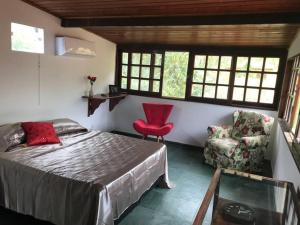 a bedroom with a bed and a chair and windows at CASA SURYA, Piscina Fantástica, Churrasqueira, Completa, 18 HÓSPEDES na REGIÃO DOS LAGOS - Casa de Campo in Iguaba Grande