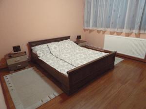 1 dormitorio con 1 cama y suelo de madera en Modern two bedroom flat with balcony, en Lenti