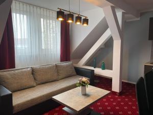 a living room with a couch and a table at Hotel Berlin in Leipzig