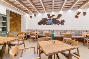 un restaurante con mesas y sillas de madera en Hotel S'Antiga Adults Only, en Es Mercadal