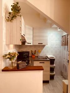 una cocina con armarios blancos y una barra con flores en JP Central Home, en Iglesias