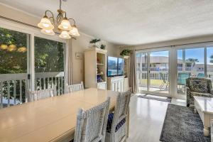 a dining room with a table and chairs and windows at Sandpiper Cove 1082 Destin Condo in Destin