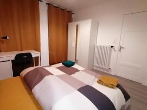 - une chambre avec un lit et une couverture noire et blanche dans l'établissement Hadriel Host, à Clermont-Ferrand