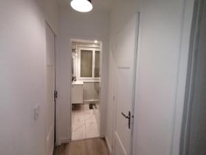 La salle de bains blanche est pourvue d'un lavabo et d'un miroir. dans l'établissement Hadriel Host, à Clermont-Ferrand