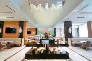 a hotel lobby with a chandelier and tables and chairs at The Rumi Hotel & Residences in Dushanbe