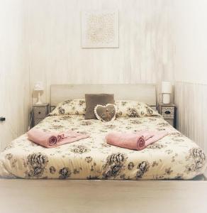 Una cama con dos almohadas rosas encima. en JP Central Home, en Iglesias