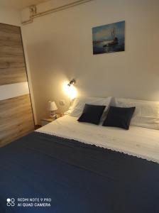 a bedroom with a large bed with black pillows at Kuća za odmor MANA in Lun