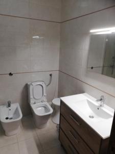 a bathroom with a toilet and a sink at Apartamento Tiago in Sines