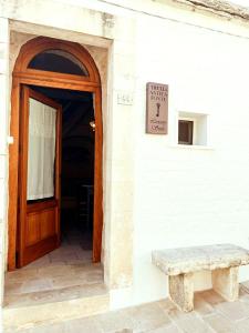 a door and a bench in front of a building at Trulli Antica Fonte Luxury Suite in Alberobello