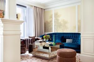 a living room with a blue couch and a table at BLESS Hotel Madrid - The Leading Hotels of the World in Madrid